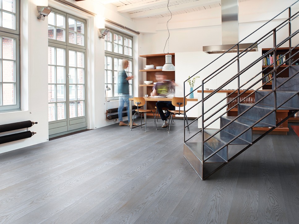 Moderner Wohnraum mit hellgrauem Echtholzboden und offener Treppe Wohnbereich mit großflächigem Echtholzboden in Grautönen, offener Treppe und modernem Interieur